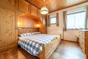 阿拉巴Tabià La Stua的木制客房内的一间卧室,配有一张床