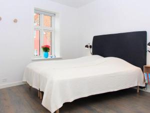 斯瓦讷克Holiday home Svaneke XLI的一间卧室配有一张白色大床和黑色床头板