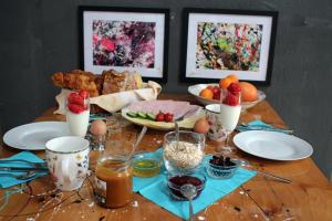 普卢巴拉内克BnB Maison d'Art Breakfast in the Art Gallery的木桌,上面有食物和水果盘