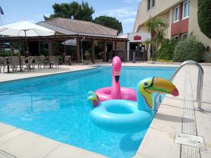 阿维尼翁南阿维尼翁宜必思酒店的水中一个粉红色和蓝色天鹅的游泳池