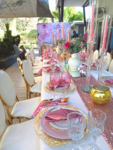 科玛蒂普特伊科拉克斯精品酒店的一张桌子,上面有粉色和金色的盘子和玻璃杯