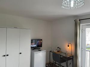 格雷斯瑟罗克Luxury Large Beds in West Thurrock 3 bathrooms 1 en suite Netflix Free Parking的客房设有书桌和墙上的电视