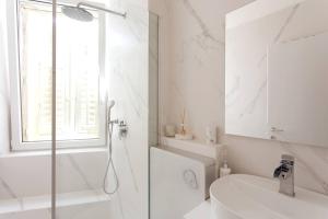 普拉Central Pula - Charming Historic Gem - Modern Comforts的带淋浴和盥洗盆的白色浴室