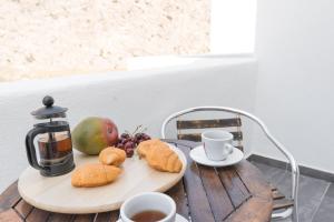 佩里萨Dodomar Selection的一张桌子,上面放着一盘饼干、水果和咖啡