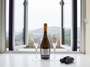马特洛克Swallow View, A Spacious Base with stunning views的桌子上放有一瓶葡萄酒和两杯酒