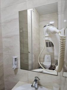 扎托卡GRAND Hotel的浴室设有镜子、盥洗盆和卫生间