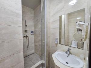 扎托卡GRAND Hotel的浴室配有盥洗盆和带镜子的淋浴