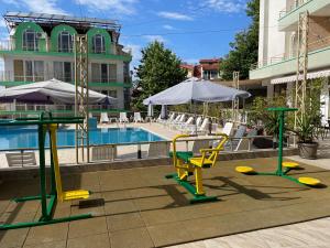 希典恩伊斯酒店的一个带椅子和桌子的游泳池以及一把遮阳伞