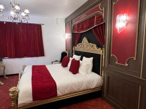 图尔奈Inthemia的一间卧室配有一张带红色窗帘的大床