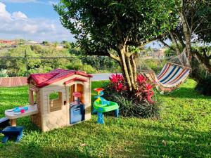 圣何塞Casa Vacacional Nieves en PZ-Piscina Privada-WIFI的玩具屋和树旁的吊床
