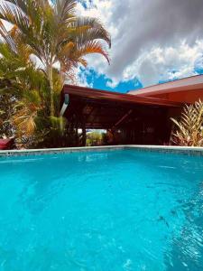 圣何塞Casa Vacacional Nieves en PZ-Piscina Privada-WIFI的一座大蓝色游泳池,位于房子前