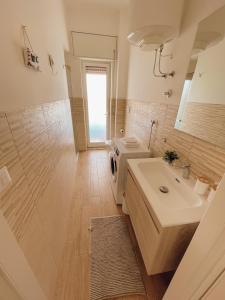 贝尔韦代雷Appartamento Corallo Rosso e Stella Blu的浴室设有白色水槽和镜子