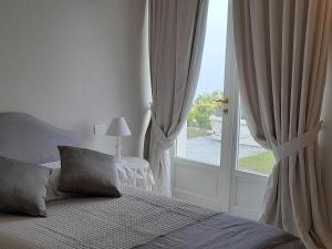 诺利VILLA AGA的一间卧室设有一张床和一个大窗户