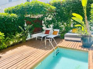 里斯本Swimming pool Apartment Central Lisbon的庭院内一个带两把椅子和一张床的游泳池