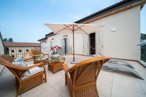 TerruggiaCascina Baronina的庭院配有椅子和桌子及遮阳伞