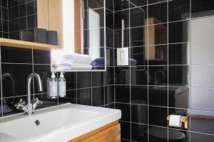 塞卡尔荷达德马迪哈乡村别墅＆餐厅的黑色瓷砖浴室设有水槽和镜子
