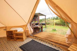 Upper HulmeRoaches Retreat Eco Glampsite - Rocky Reach Bell Tent的田野上带木甲板的帐篷