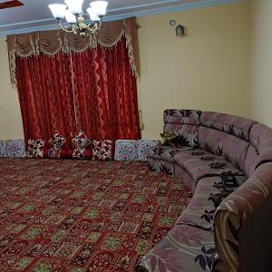 斯利那加New urban Den cottage的带沙发和红色窗帘的客厅