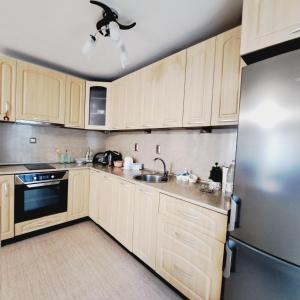 扬博尔Apartment RELAX in the city center, free parking的厨房配有木制橱柜和不锈钢冰箱。