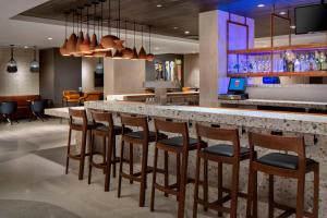 皇后区纽约拉瓜迪亚机场万豪酒店 的餐厅内的酒吧配有椅子和柜台