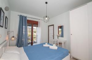 根纳迪佩特拉别墅的一间卧室设有蓝色的床和窗户。