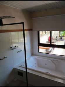 卡萨布兰卡Pousada Verde Folhas的带浴缸的浴室和窗户