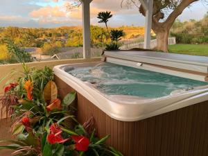 唯客乐渡假村Coastal Waikoloa Cottage Sleeps 10的鲜花阳台的按摩浴缸