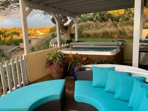 唯客乐渡假村Coastal Waikoloa Cottage Sleeps 10的一个带2把蓝色椅子和热水浴缸的庭院