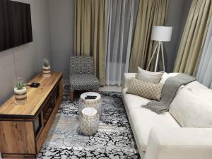 Pretoria-NoordKings view exclusive villas (KVEV)的客厅配有白色的沙发和桌子