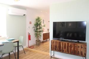 里斯本Lisbon, T2 renewed duplex with river view, Beato, Lisbon的木制娱乐中心的客厅配有大屏幕平面电视