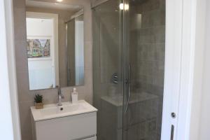 里斯本Lisbon, T2 renewed duplex with river view, Beato, Lisbon的带淋浴、盥洗盆和镜子的浴室