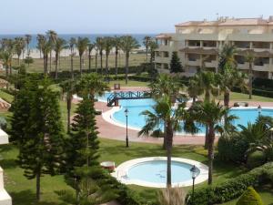滨海罗克塔斯Ap-to Frente al Mar VillaRomana的享有度假村的空中景致,设有游泳池和棕榈树