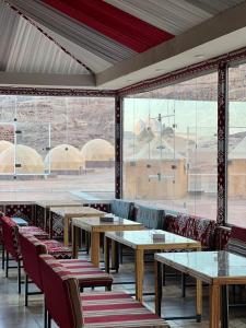 DisahLulua luxury camp的餐厅设有桌椅和大窗户。