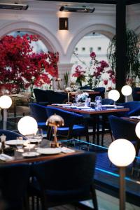 地拉那Xheko Imperial Luxury Hotel & SPA的一间带桌椅和红花的餐厅