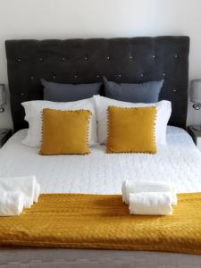丰沙尔Alexia Room的一张大床,上面有黄色和白色的枕头
