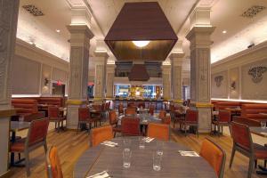 纽约爱迪生时代广场酒店的一间带桌椅和大吊灯的餐厅