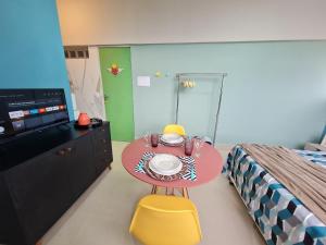 瓜拉派瑞GUARALOFT ARUBA NO MIRANTE DE GUARAPARI的卧室配有粉红色的桌子、床和电视。