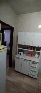 乌贝拉巴Casa de Boneca aconchegante的厨房配有白色橱柜和台面