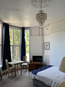 斯旺西Ensuite Double Room, by Swansea University, Sketty, R2的一间卧室配有一张床、一张桌子和一个吊灯。