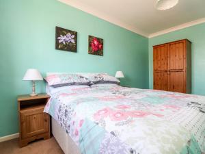 法尔茅斯Dragonflies & Seahorses的一间卧室配有一张床和床头柜,配有四柱床和四柱床。