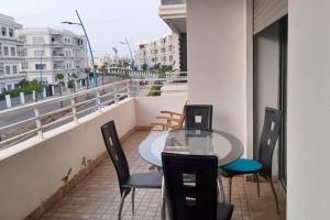 穆罕默迪耶Residence Mansbay Mansouria Beach pool WIFi的大楼阳台上的桌椅