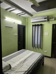 拉加蒙德里Sreenilayam Luxury Stay Homes的一间卧室设有一张带绿色墙壁和天花板的床。