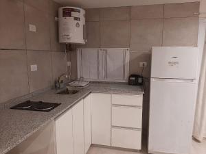 布兰卡港Alquiler por día Bahía Blanca的厨房配有白色橱柜和白色冰箱。