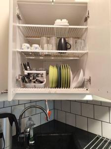 赫尔辛基Studio in Kallio的厨房水槽,架子上摆放着盘子和盘子