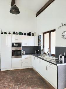 托尔雷莱splendide maison catalane renovee avec grande terrasse et garage的厨房配有白色橱柜和墙上的时钟