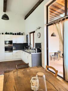 托尔雷莱splendide maison catalane renovee avec grande terrasse et garage的厨房以及带木桌的用餐室。