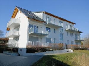巴特贝林根Golf & Wellness Suite Bad Bellingen Apartment 5-9的带阳台和庭院的白色公寓大楼