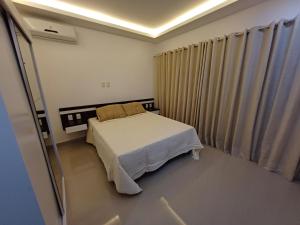 里约热内卢Loft em Olaria的一间带床和窗帘的小卧室