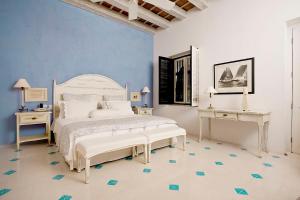 卡塔赫纳卡萨奎罗酒店的卧室配有白色的床和蓝色的墙壁