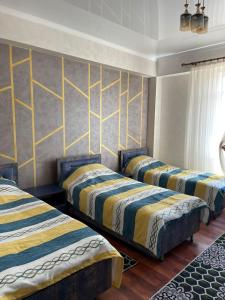 Kaji-SayCHINAR hotel的黄色和蓝色条纹的客房内的三张床